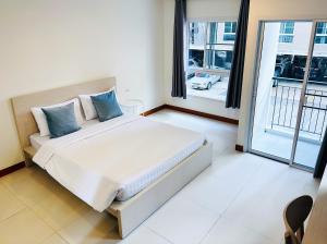 曼谷The Lodge @ Min Residence的一间卧室设有一张大床和一个大窗户