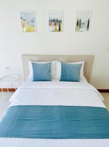 曼谷The Lodge @ Min Residence的卧室内的一张带蓝色枕头的大床