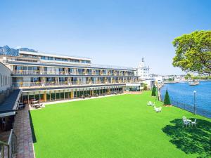 岛原市Hotel Seaside Shimabara的一座大建筑,水面上有一个绿色草坪