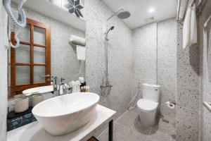 河内Le Parfum Apartment and Hotel的浴室配有大型白色水槽和卫生间