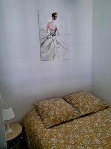 布雷斯地区布尔格La Maison du Bonheur的一张墙上挂着女人照片的床