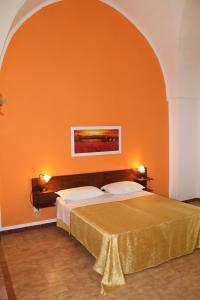 赛拉诺B&B Masseria Donna Carlotta的一间卧室配有一张橙色墙壁的床
