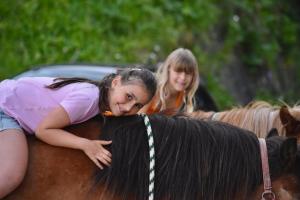 圣维吉利奥Ciasa Pedaga的两个年轻女孩骑在马背上