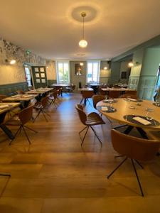 BoussacHotel Le Central的餐厅铺有木地板,配有桌椅