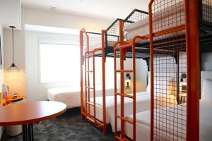 浦安东京湾宜必思尚品酒店的客房设有两张双层床和一张桌子。