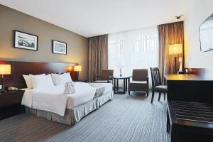 哥打京那巴鲁六十三酒店的配有一张大床和一架钢琴的酒店客房