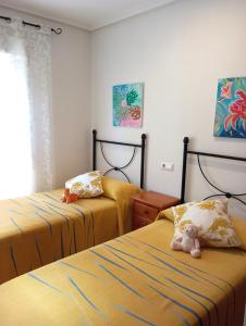 维拉Casa Brisa Marina Vera的一间卧室配有两张床,卧室上摆放着泰迪熊