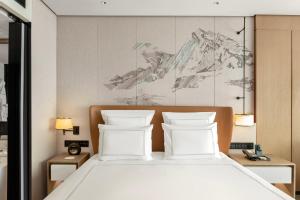 北京北京港澳中心瑞士酒店的卧室配有白色的床和2个枕头