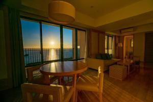 宜野湾市月球海洋宜野湾公寓酒店的客厅配有桌子,享有海景