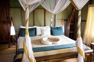 MkwajaSimply Saadani Camp, A Tent with a View Safaris的一间卧室配有一张带天蓬的床