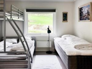 BygstadFour-Bedroom Holiday home in Bygstad 1的一间卧室设有两张双层床和一扇窗户。