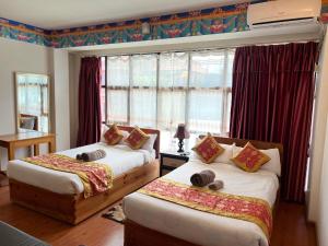 加德满都博达哈酒店的一间卧室设有两张床和窗户。