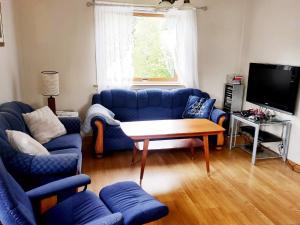 BygstadFour-Bedroom Holiday home in Bygstad 1的客厅配有蓝色的沙发和桌子