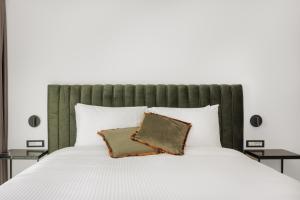 约阿尼纳Cens Silver Luxury Suites的一间卧室配有一张白色床和绿色床头板