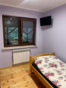 GibyAgroturystyka Nad Czarnym的卧室配有一张床,墙上配有电视。