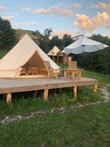 DseghAlereks Mountain Camping的一个带桌子和雨伞的帐篷