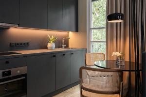 慕尼黑HApato的厨房配有黑色橱柜、桌子和窗户。