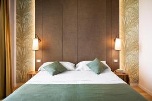 里米尼生活酒店的一间卧室配有一张大床和两个绿色枕头
