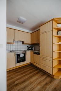 伊尔米茨Ferienwohnung Illy的厨房铺有木地板,配有木制橱柜。