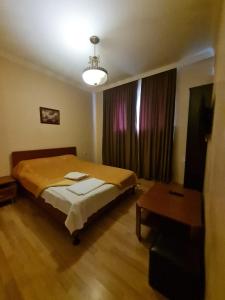 第比利斯皮亚诺酒店的一间卧室配有一张床和一张桌子