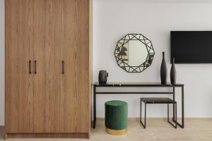 约阿尼纳Cens Bronze Luxury Suites的客房设有书桌、镜子和凳子
