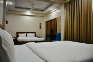 加尔各答Hotel Royal Residency的酒店客房设有两张床和窗户。