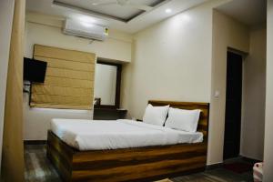 加尔各答Hotel Royal Residency的一间卧室配有一张带白色床单的大床