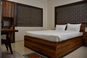 加尔各答Hotel Royal Residency的一间卧室配有一张大床、一张桌子和一张书桌