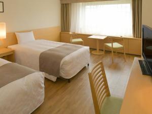 札幌Sapporo View Hotel Odori Park的酒店客房设有两张床和一张桌子。