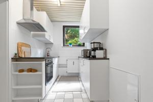 慕尼黑Flatista Homes - Garden House的厨房配有白色橱柜和窗户。