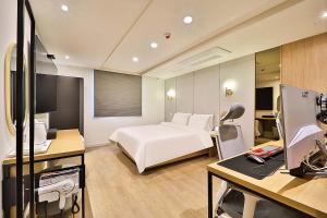 蔚山Hotel Rubato Ulsan Jung-gu Haksung的酒店客房配有一张床和一张带电脑的书桌