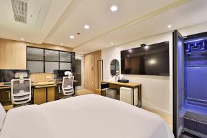 蔚山Hotel Rubato Ulsan Jung-gu Haksung的一间卧室配有一张床、一张桌子和一台电脑