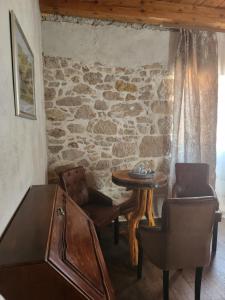 特里班Boutique Vila Marijini Dvori的配有桌椅和石墙的房间