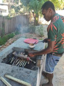 Nosy KombaVilla Ilo Komba的一个人在烧烤架上做饭