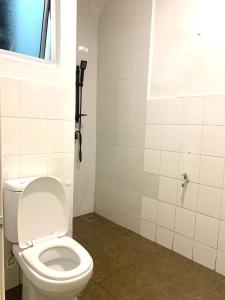 帕帕尔Adel Homestay的一间带白色卫生间的浴室和窗户。