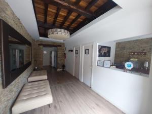 LorenzanaALBERGUE CASTELOS的走廊上设有2张长椅,位于带天花板的房间内