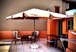 干尼亚Casa Mersini的庭院配有遮阳伞和桌椅。