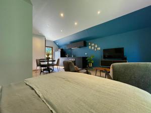 ToucyEcrin de Vizaille的一间拥有蓝色墙壁的卧室、一张床和一间客厅