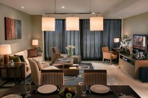 曼谷邦纳自豪公寓式酒店的客厅配有沙发和桌椅