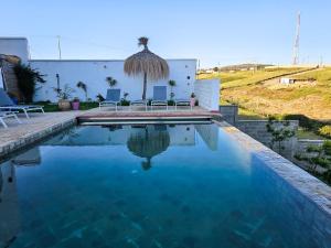 丹吉尔Très belle villa avec piscine et vue incroyable sur mediterannée (DAR NAIM)的一座房子前面的蓝色海水游泳池