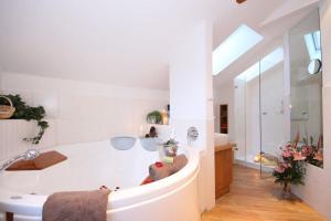 奥夫特尔施旺Landhotel Alphorn的白色的浴室设有浴缸和水槽。