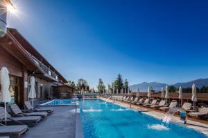 班斯科Katarino SPA Hotel的度假村的游泳池配有椅子和遮阳伞