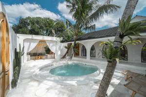 科贾扬Bohemian Jogja Villas with Private Pool的棕榈树庭院的游泳池