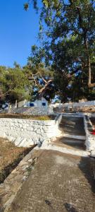 阿加索尼西岛Odysseas apartments的一个带长凳和树的石头公园