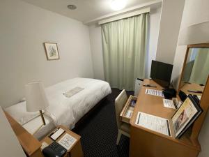 磐城岩城大公园酒店的酒店客房配有一张床和一张带电脑的书桌