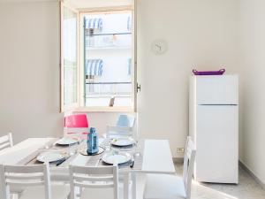 皮内托Homiday - BordoPineta Centro的白色的用餐室配有桌子和冰箱