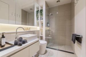 墨尔本Charming 1-Bedroom Heritage Apartment的白色的浴室设有水槽和淋浴。