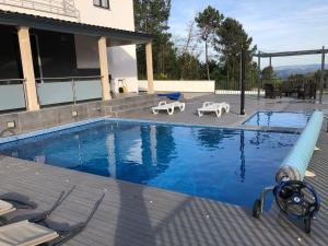 维拉·雷阿尔Moradia Activ Mar\Vão的一个带两把草坪椅的游泳池和一个游泳池