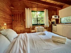埃米瑞姆Adventure - חוויה的小木屋内一间卧室配有一张白色的床