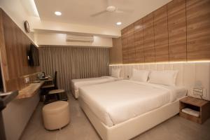 孟买Hotel Naaz Executive的酒店客房配有两张床和一张书桌